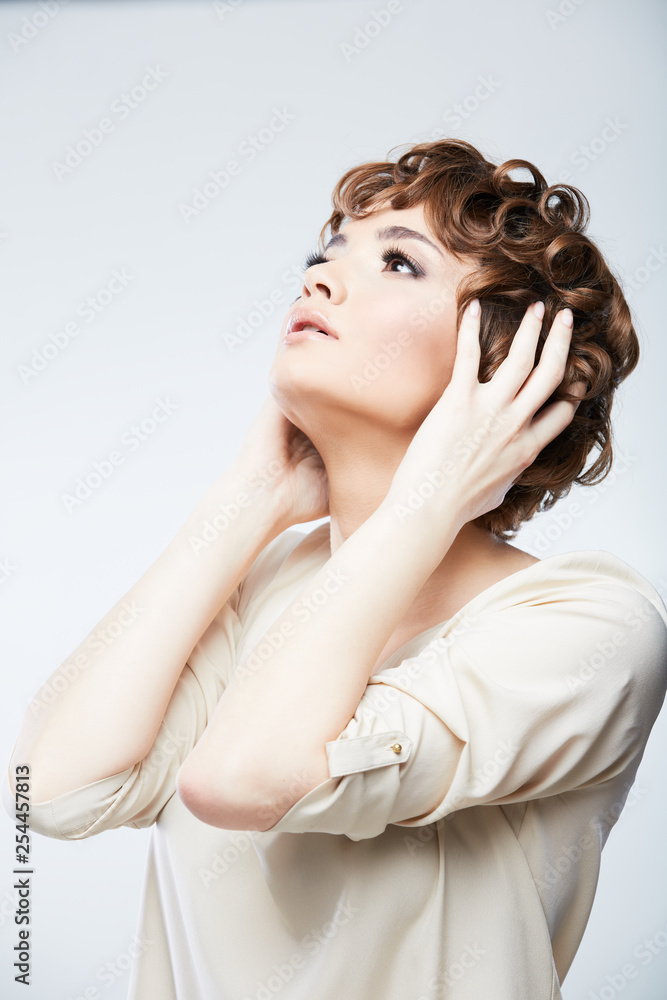 Obraz premium Fashion style portrait of young woman with short curly hair.