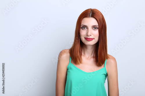 Beautiful redhaired woman on grey background