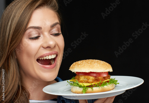 Woman holding burger on white plate