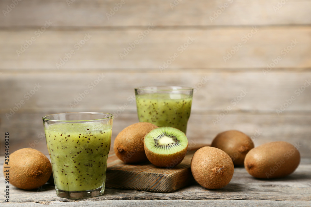 Fresh kiwi smoothie in glass on grey wooden table