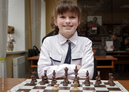 The girl plays chess. Figures on a chessboard. Game of chess.