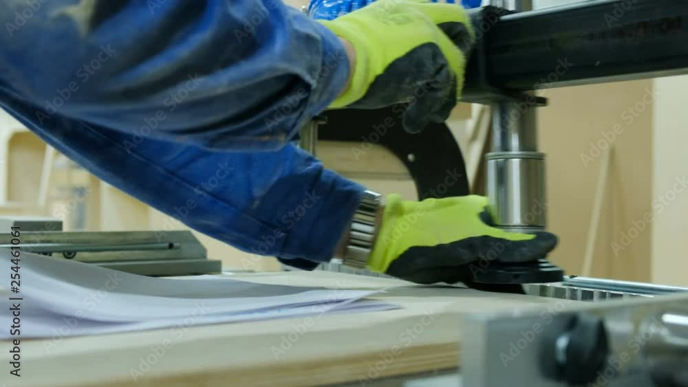 Carpenter sets up a drilling machine. Manufacture of wooden furniture Carpenter sets up a drilling machine. Manufacture of wooden furniture