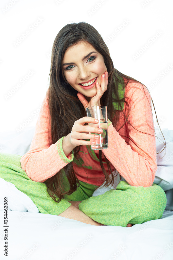 smiling young woman holding water glass.