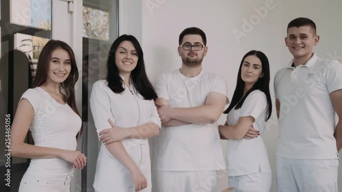 Portrait of happy, confident dentists look at camera with crossed hands photo