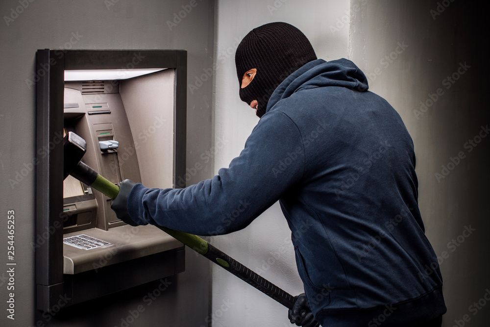 Thief. Hacker stealing money from ATM machine. Phishing, ATM skimming Thief. Hacker stealing money from ATM machine. Phishing, ATM skimming