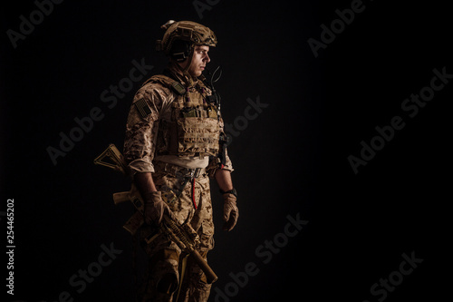 Special forces United States soldier or private military contractor holding rifle. Image on a black background. war, army and people concept