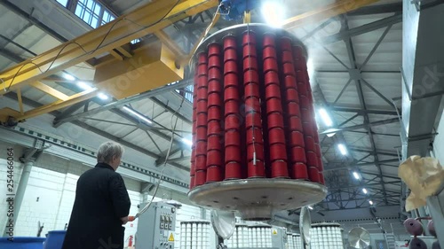 Textile factory female worker works with thread coloring machine. Modern technology in dyeing yarns with Machines for Textile Industry, Dyeing Machine Chemical Tanks
