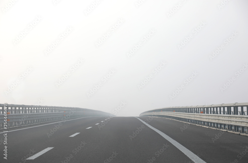 highway with dense dangerous fog without cars during a days in w