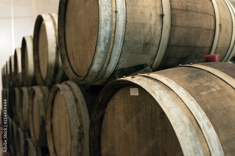 Wine barrels stacked in the old cellar of the winery. 