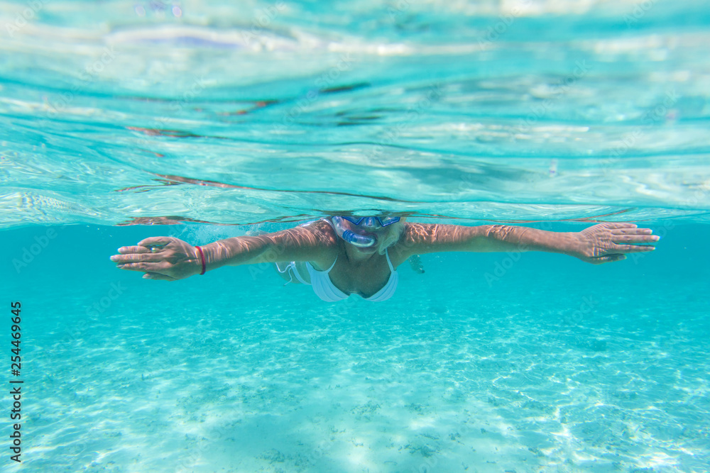 Woman snorkeling in clear water on Maldives Islands .Underwater view. 