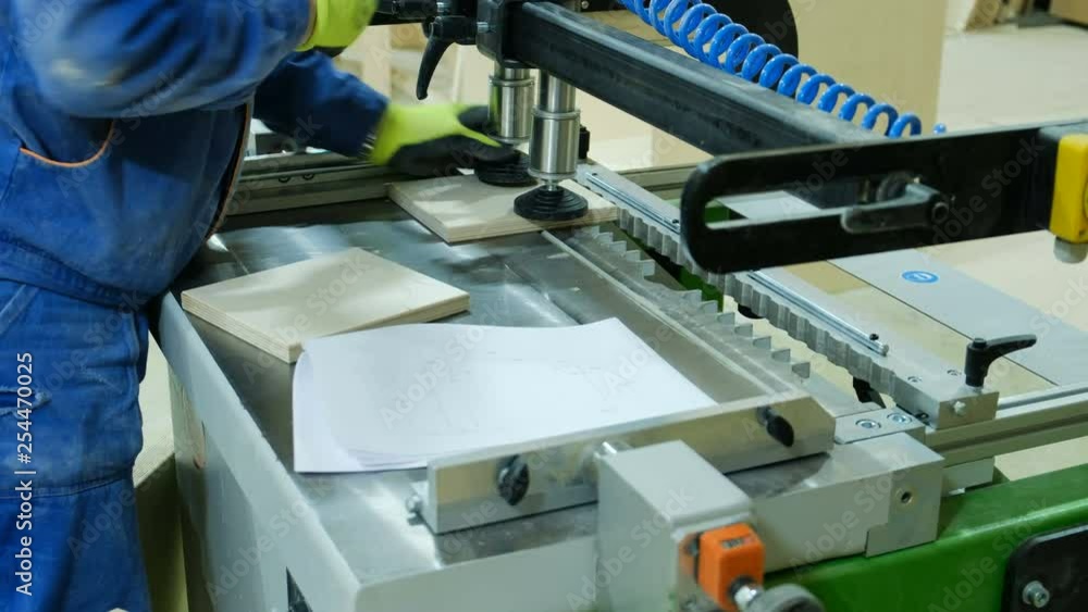 Work on modern drilling woodworking machine at a furniture factory Work on modern drilling woodworking machine at a furniture factory