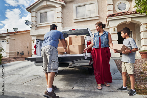 Canvas Print hispanic family unloading pickup truck and moving into new house in las vegas