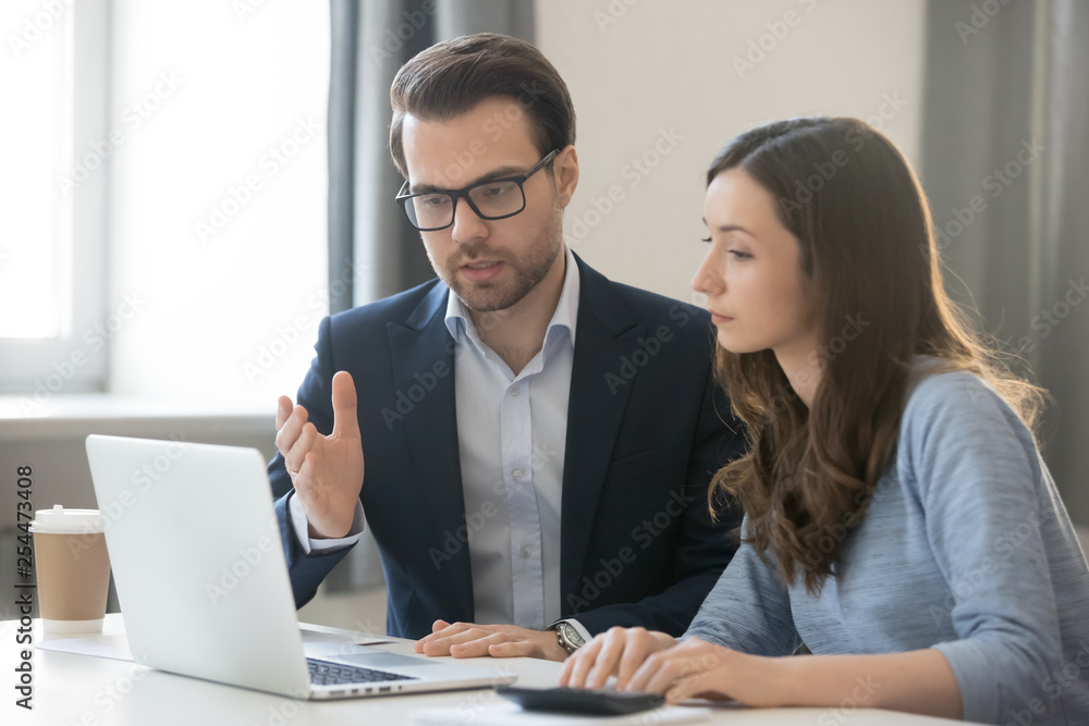 Helpful boss mentor explaining new online project to worker intern Helpful boss mentor explaining new online project to worker intern