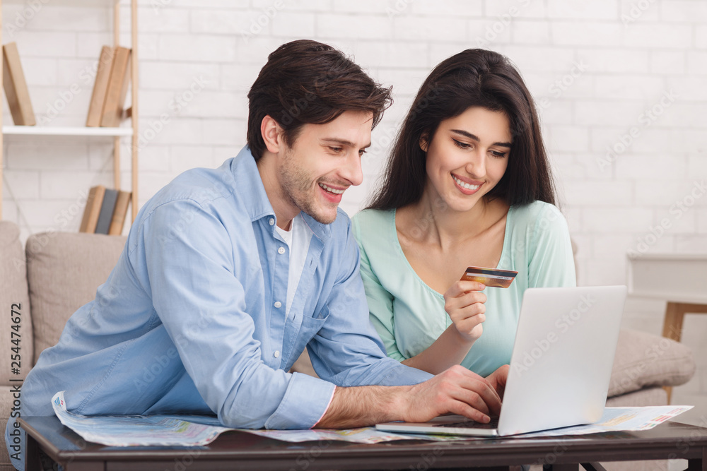 Happy couple booking hotel online on laptop Happy couple booking hotel online on laptop