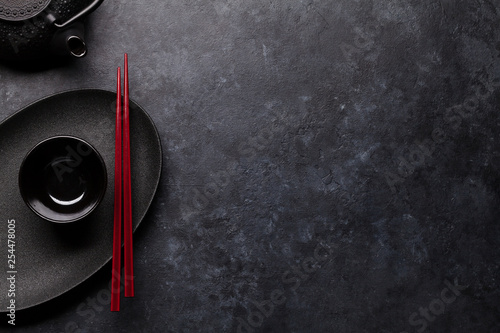 Empty plate, teapot and chopsticks photo