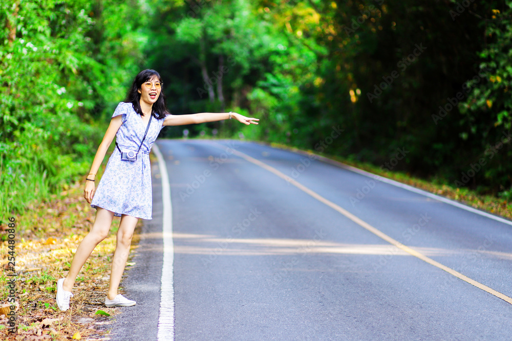 Woman hand waving for a car aside the road Woman hand waving for a car aside the road