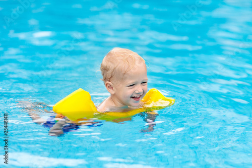 Baby in swimming pool. Kids swim.
