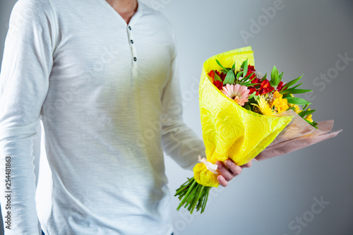 man hand holding flowers bouquet