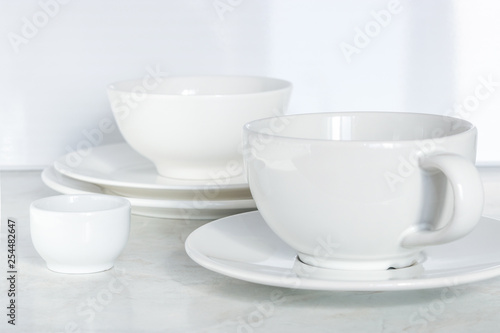 set of white dishes. empty cup bowls plates on the table soft focus