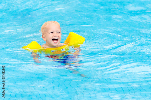 Baby in swimming pool. Kids swim.