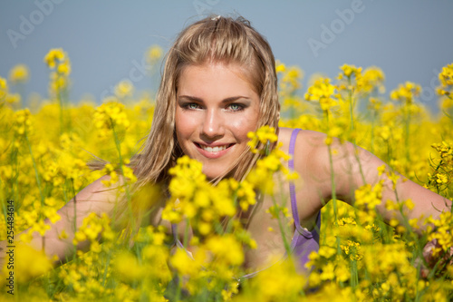 young woman in yellow canola field