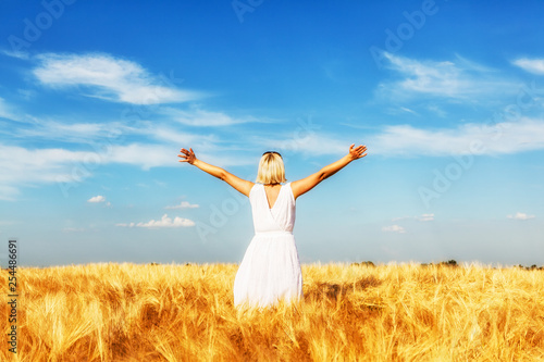 rear  view of happy woman in wheat field © Avatar_023