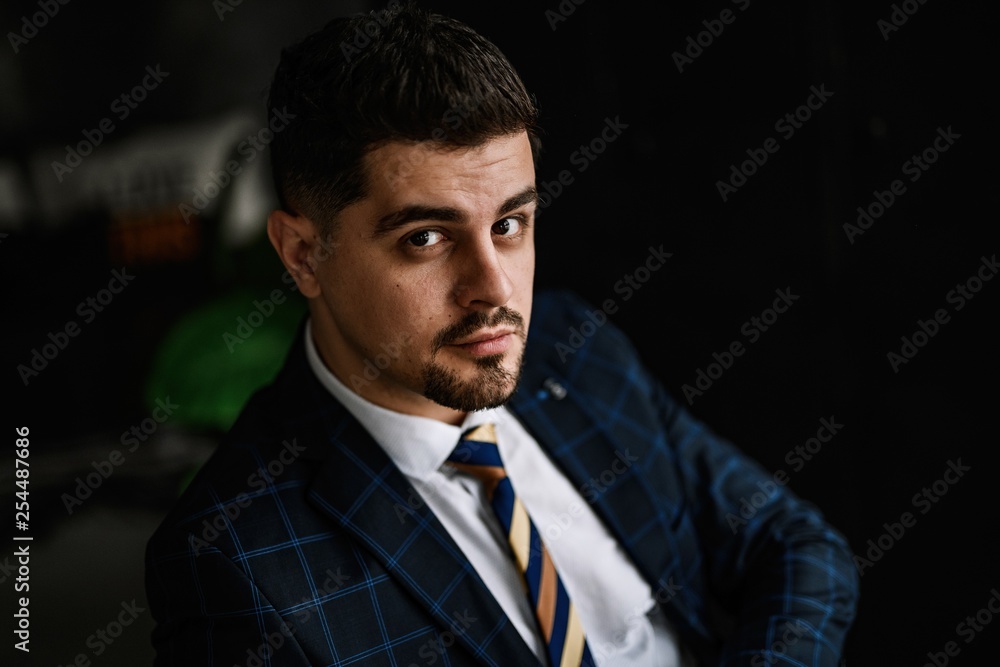 A handsome man in a blue suit in a cage posing in the Studio. Business portrait. A handsome man in a blue suit in a cage posing in the Studio. Business portrait.