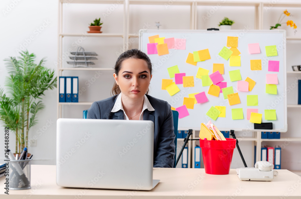 Young female employee in conflicting priorities concept 