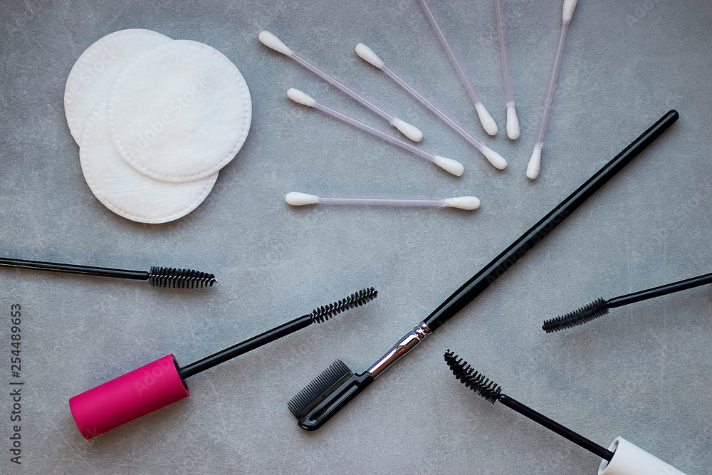 Brushes for mascara, cotton buds, cotton pads and a comb for eyelashes on a gray background. Tools and devices for makeup eyelashes. Brushes for mascara, cotton buds, cotton pads and a comb for eyelashes on a gray background. Tools and devices for makeup eyelashes.