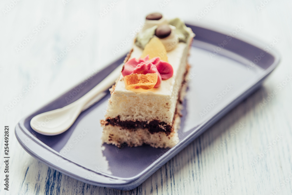 A slice of sponge cake on a rectangular plate.