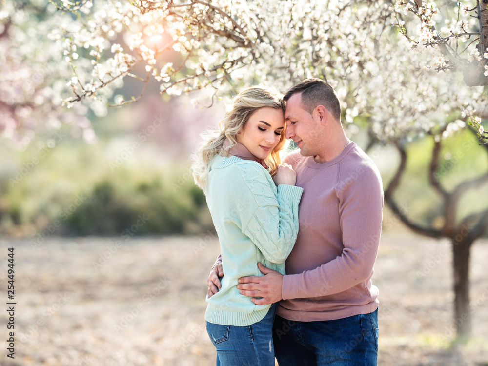 Fototapeta premium Beautiful couple in the flowering gardens in the spring