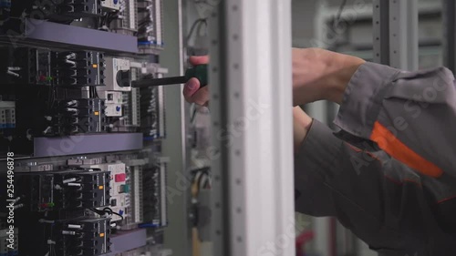 Wallpaper Mural a professional assembles an electrical circuit and twists a screwdriver Torontodigital.ca