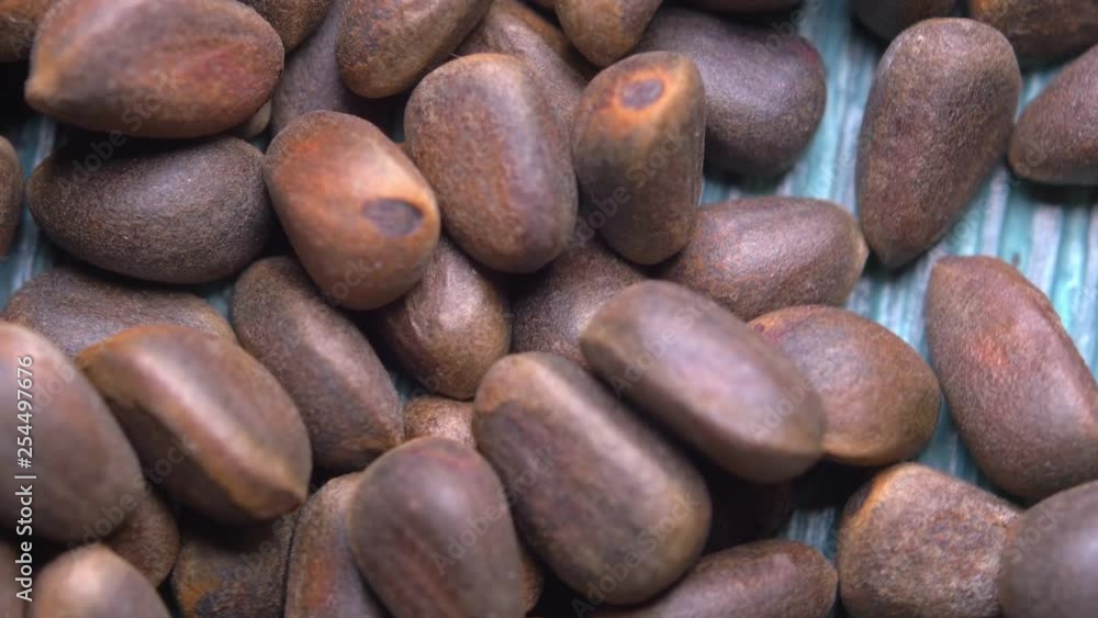 Macro close-up pine nuts on a natural wooden background, rotate 360, 4K UHD video
