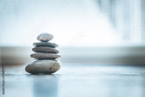Photography Feng Shui: Zen stones on the wooden floor, bright light is coming through the wi