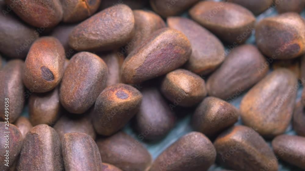Macro close-up pine nuts on a natural wooden background, rotate 360, 4K UHD video Macro close-up pine nuts on a natural wooden background, rotate 360, 4K UHD video