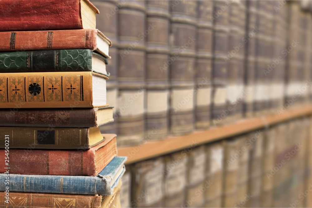 Ancient books in a row on wooden background Ancient books in a row on wooden background