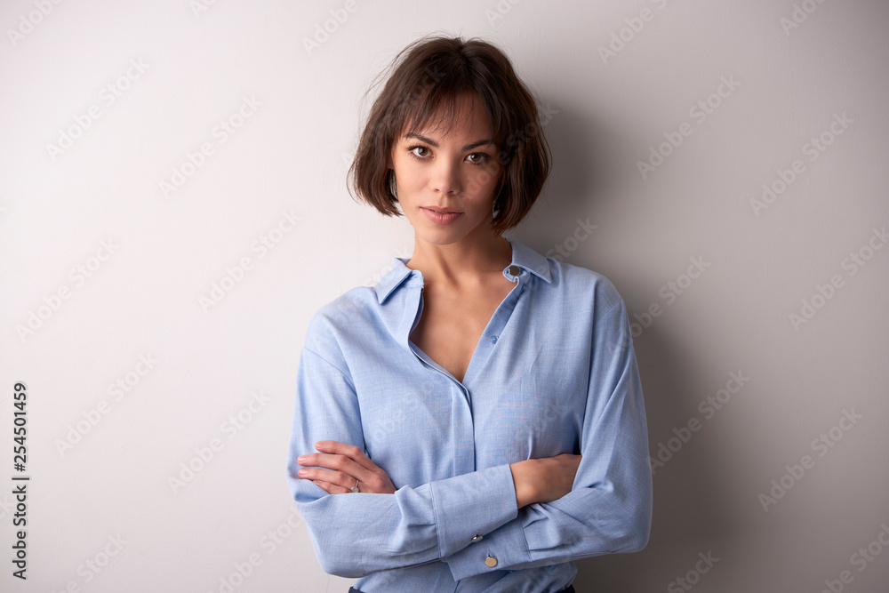 Attractive businesswoman with folded arms standing at isolated background Attractive businesswoman with folded arms standing at isolated background