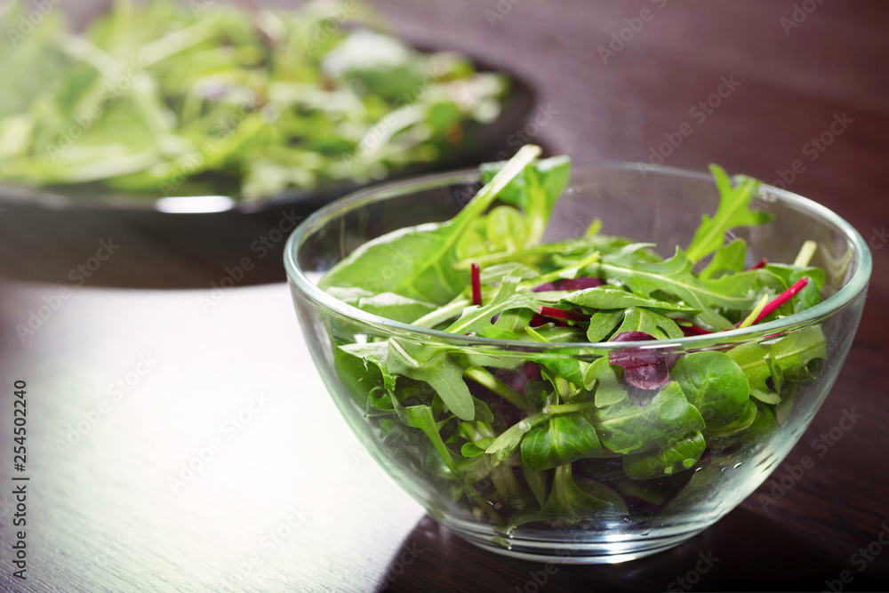 A mixed raw salad from the leaves of arugula, spinach and romaine, a close-up. A mixed raw salad from the leaves of arugula, spinach and romaine, a close-up.