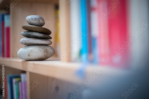 Feng Shui: Stone cairn in a book shelf in the living room, balance and relaxation
