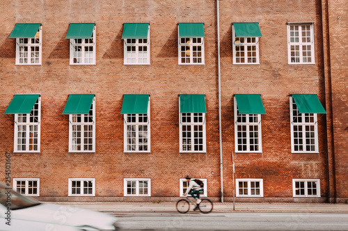 Photography City with brick houses and cyclists driving on historical streets of Copenhagen, Denmark