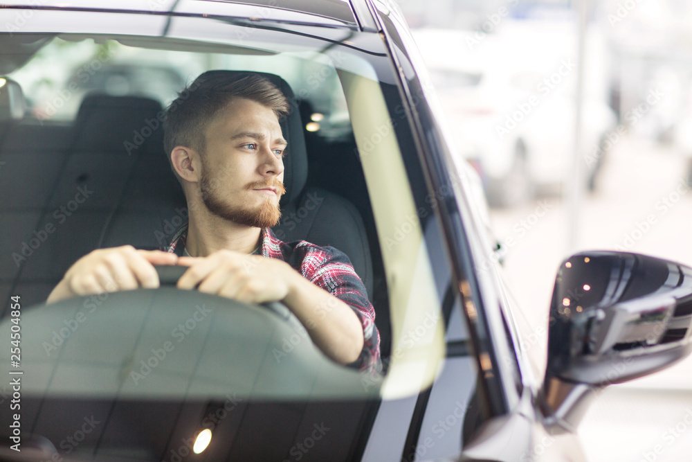 Handsome young man in his new automobile Handsome young man in his new automobile
