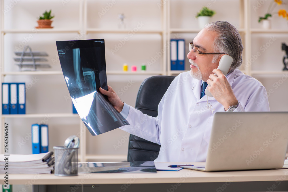 Aged male doctor radiologist in the clinic Aged male doctor radiologist in the clinic