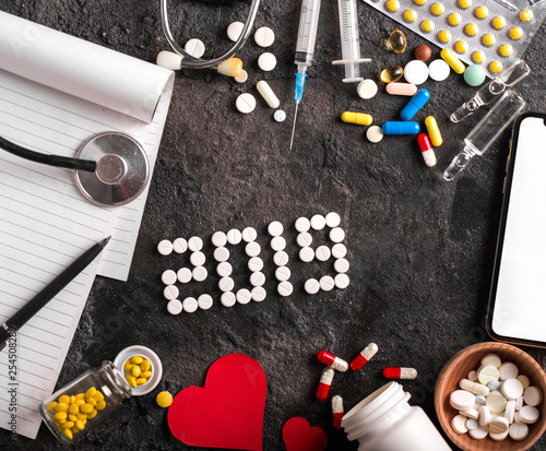 Assorted pharmaceutical medicine pills, tablets and capsules. 2019 year black background. photo