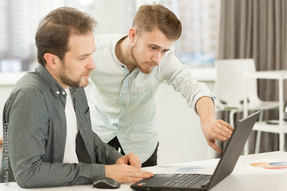 Two businessmen working at the office together Two businessmen working at the office together