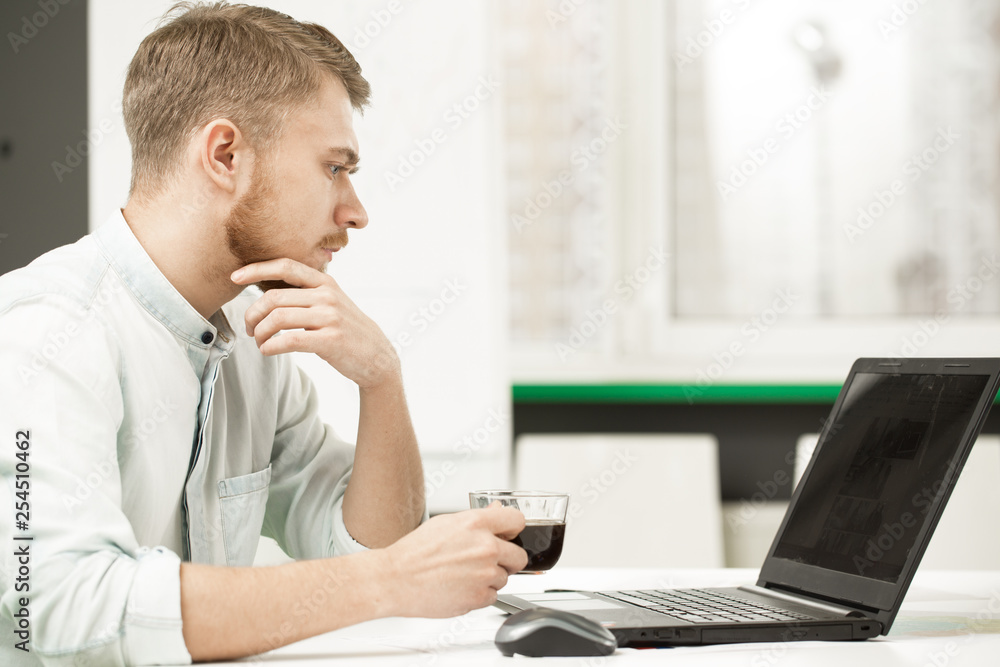 Young handsome businessman working at his office