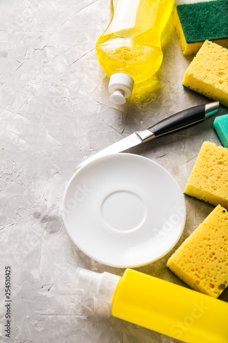 flat lay composition with cleaning supplies for dish washing and space for text on grey background
