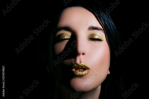 Young beautiful woman with bright makeup on a black background.