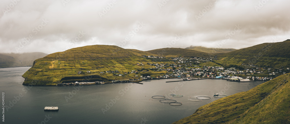 panorama of the town Vestmanna in Faroe Islands with the fjord, fishing nets camping site in the summer panorama of the town Vestmanna in Faroe Islands with the fjord, fishing nets camping site in the summer