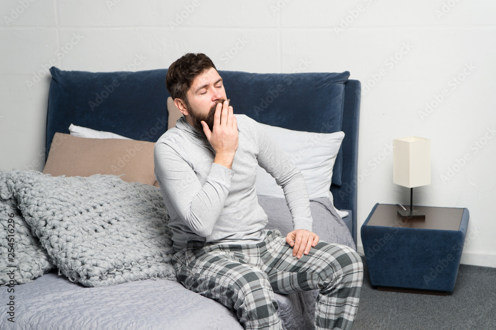Get up early. Tips for waking up early. Man bearded hipster sleepy face waking up bedroom interior. Schedule for healthy lifestyle. Sweet yawn. Rest and relax. Problem with early morning awakening Get up early. Tips for waking up early. Man bearded hipster sleepy face waking up bedroom interior. Schedule for healthy lifestyle. Sweet yawn. Rest and relax. Problem with early morning awakening