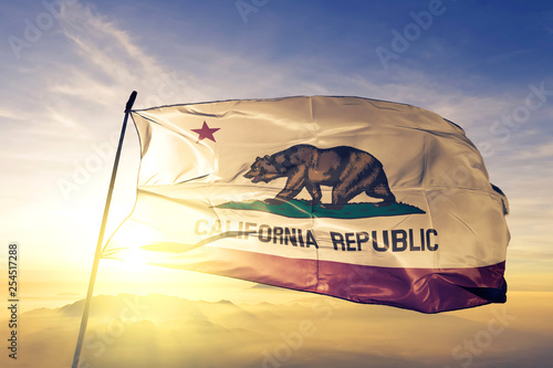 Billede på lærred California state of United States flag waving on the top sunrise mist fog